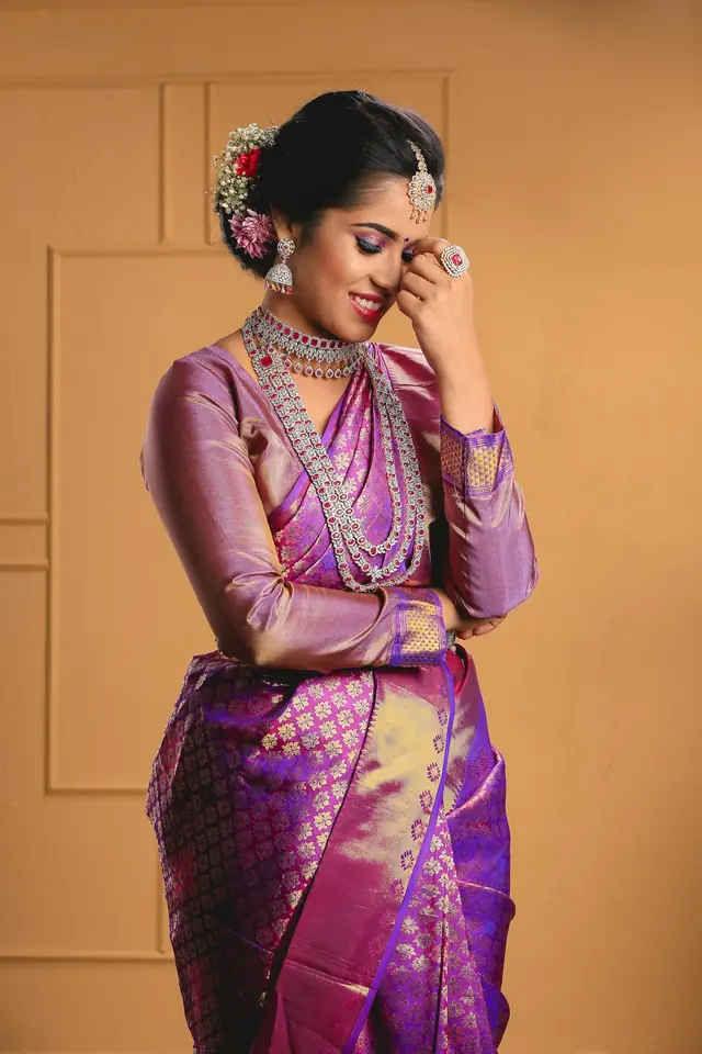 Woman in a purple and gold silk saree